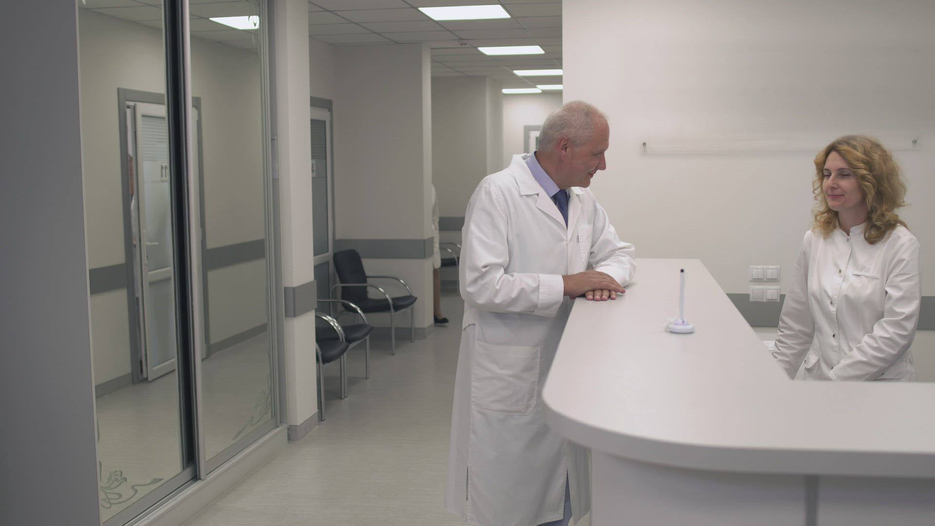 Personal de una clínica conversa en el mostrador de recepción
